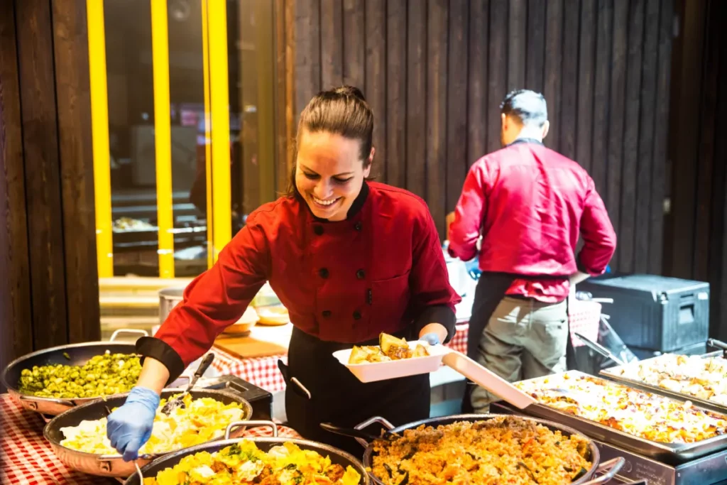 Two people serving pasta