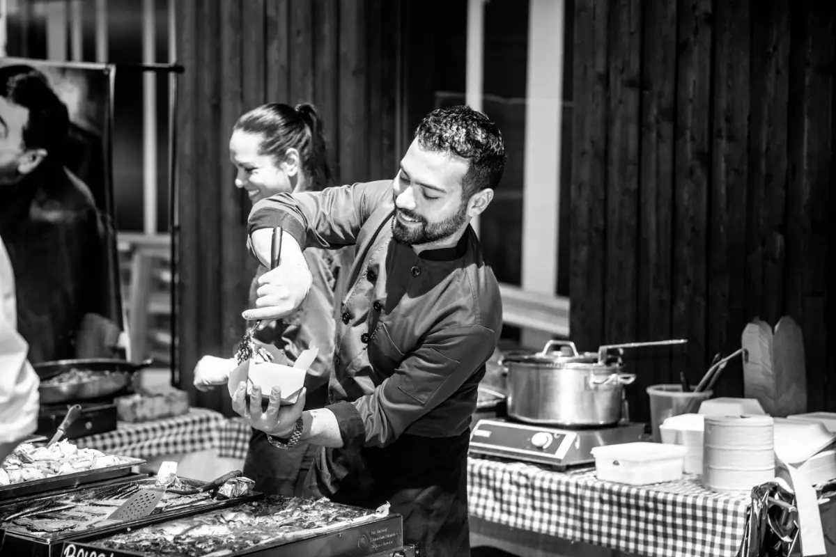 Two people serving pasta